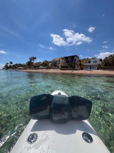 a boat in the water next to a beach at Zalooma House I Beachfront Hostel Dahab in Dahab