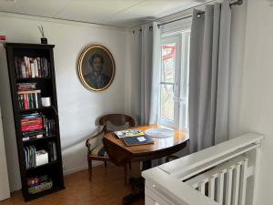 a room with a table and a book shelf at Charming Bed & Breakfast - Villa Högby in Löttorp