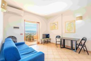 a living room with a blue couch and a table at A.I.R. Isola Rossa Borgo di Mare in Isola Rossa