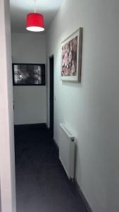 a hallway with a white wall with a picture and a radiator at PLUS Properties Westport 3 in Stoke on Trent