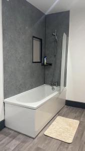 a white bath tub in a bathroom with a mirror at PLUS Properties Westport 3 in Stoke on Trent