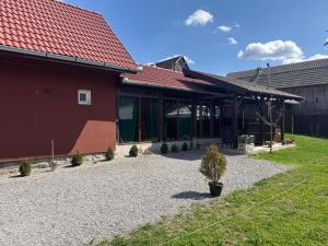 a building with a red roof and a yard at Casa Lemnarului in Micfalău