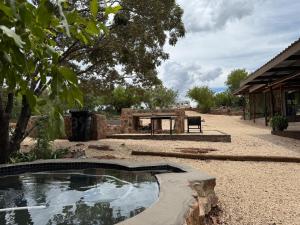 a pool of water in a yard with a bench at Boskoors in Hammanskraal