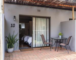 a patio with a table and chairs and a bedroom at Purdy's Place in Louis Trichardt