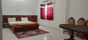a bedroom with a bed and a table and chairs at Hotel & Bothgaya Waterpark in Bodh Gaya