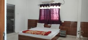 a bedroom with a bed with a red curtain at Hotel & Bothgaya Waterpark in Bodh Gaya
