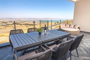 a table and chairs on a patio with a view at רויאל טווינס בוטיק in Safed