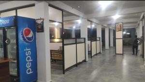 a hallway in a building with a pepsi machine at Salt Restaurant and Lodging in Navalgund