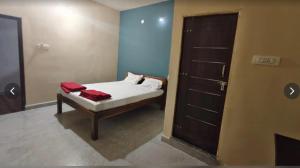 a small bedroom with a bed and a door at Salt Restaurant and Lodging in Navalgund
