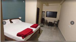 a bedroom with a bed with a red blanket on it at Salt Restaurant and Lodging in Navalgund