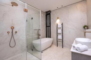 a bathroom with a tub and a glass shower at רויאל טווינס בוטיק in Safed +15 photos