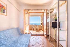 a living room with a couch and a view of the ocean at A.I.R. Isola Rossa Borgo di Mare in Isola Rossa
