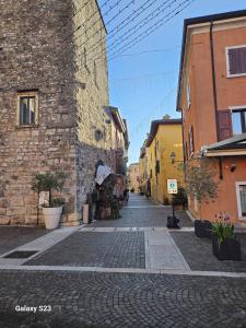 a cobblestone street in a city with a building at Appartamento Torri del Benaco in Torri del Benaco +3 photos