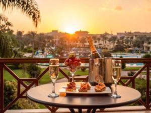 a table with a bottle of champagne and two glasses at Mövenpick Cairo Media City in 6th Of October