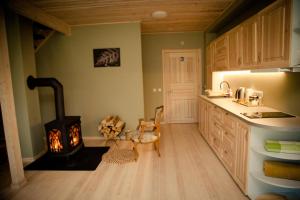 a kitchen with a wood stove in the corner at Atpūtas un sporta komplekss Mednieki - atpūta dabā, pie ezera in Salainis