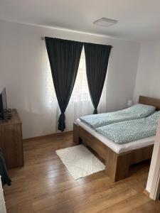 a bedroom with a bed and a window at Casa Lemnarului in Micfalău