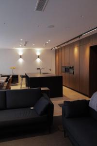 a living room with two couches and a kitchen at Sunset Edge Villa - 77 Retreats in Għajn Tuffieħa