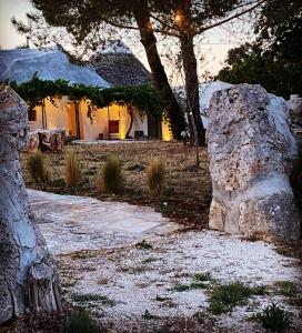 a house with two large rocks in front of it at Masseria Noja in Noci