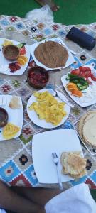 a table with plates of food on it at Zalooma House I Beachfront Hostel Dahab in Dahab