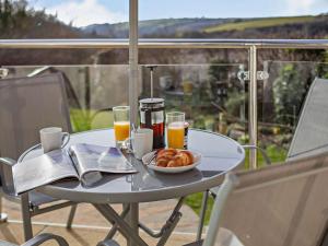 a table with a bowl of food and two glasses of orange juice at 2 Bed in Bude oc-87225 in Kilkhampton