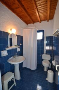 La salle de bains est pourvue de carrelage bleu, d'un lavabo et de toilettes. dans l'établissement Villas Kalafatis Apartments, à Kalafatis
