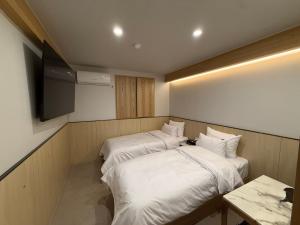 two beds in a small room with a television at Latree Hotel in Seoul