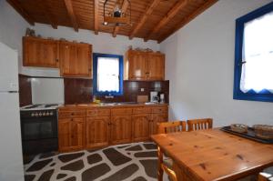 a kitchen with wooden cabinets and a wooden table at Villas Kalafatis Apartments in Kalafatis +31 photos