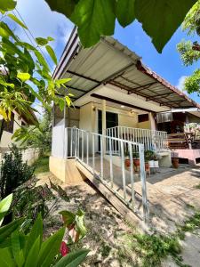 a house with a white fence in front of it at บ้านสวนบรรจงอักษร Bansuan Banjong Akkson in Rayong