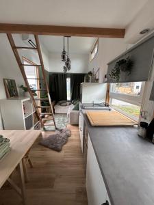 a kitchen with a counter top and a living room at Tiny Haus in Rastederberg