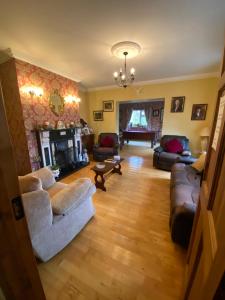 a living room with couches and a fireplace at Deerpark Manor Bed and Breakfast in Swinford