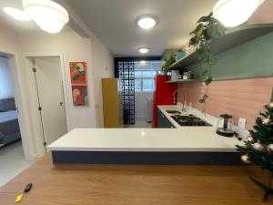 a kitchen with a white counter and a christmas tree at Incrível apto com banheira e garagem perto de tudo in Florianópolis +6 photos