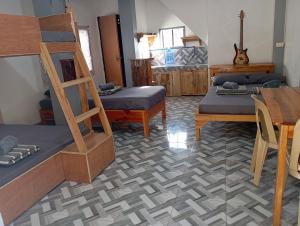 a room with three bunk beds and a table at Joan's All Seasons Homestay in Taccon
