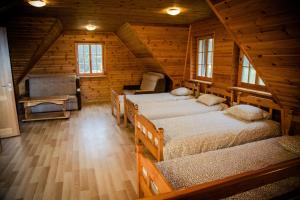 a room with four beds in a log cabin at Atpūtas un sporta komplekss Mednieki - atpūta dabā, pie ezera in Salainis