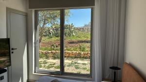 a window in a room with a view of a field at Sunset Edge Villa - 77 Retreats in Għajn Tuffieħa