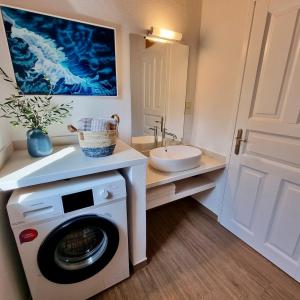 a bathroom with a washing machine and a sink at The House of Waves in Kotrónion