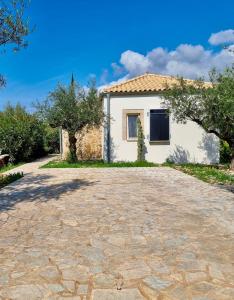 a house with a stone driveway at The House of Waves in Kotrónion