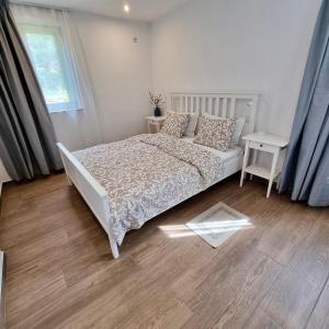 a bedroom with a white bed and a wooden floor at The House of Waves in Kotrónion