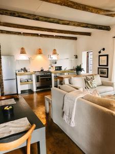 ein Wohnzimmer mit zwei Sofas und einer Küche in der Unterkunft Ashbourne Country Escape Hazyview in Hazyview