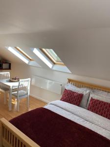 a bedroom with a bed and a table and skylights at Cedar Lodge in Torpoint