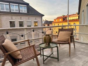 a patio with two chairs and a table on a balcony at MurgLoge Gaggenau in Gaggenau