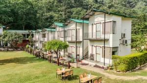 a row of houses with tables and chairs at Aspen Riverside Resort in Rishīkesh