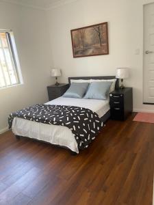 a bedroom with a bed and a wooden floor at Lidcombe Olympic Park Dudley in Auburn