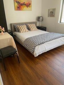 a bedroom with a bed and a table with a chair at Lidcombe Olympic Park Dudley in Auburn