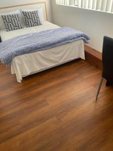 a bedroom with a bed and a wooden floor at Lidcombe Olympic Park Dudley in Auburn