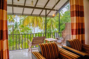 a screened in porch with chairs and a table at Lake Edge Resort in Hambantota