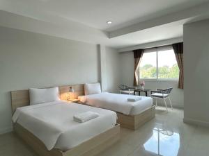 a bedroom with two beds and a desk and a window at DD Boutique Resort in Ban Wat Pa +83 photos