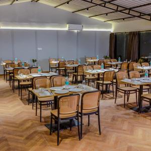 a large room with tables and chairs and a chalkboard at Aspen Riverside Resort in Rishīkesh