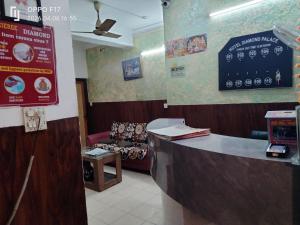 a waiting room with a counter and a couch at Hotel Diamond palace 45C in Chandīgarh +3 photos