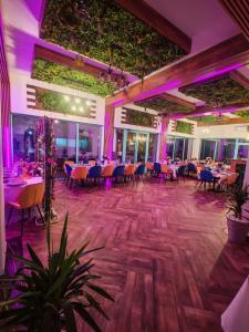 a banquet hall with tables and chairs and purple lighting at Pensiunea Aura Deltei in Murighiol