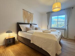 a bedroom with a large bed and a window at MurgLoge Gaggenau in Gaggenau